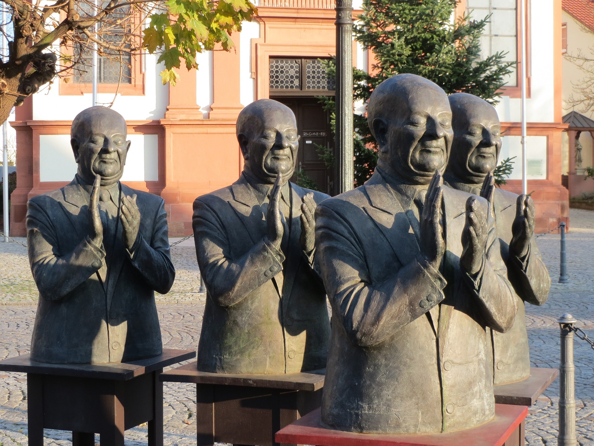 Statyn "The Claque" från den tyska staden Schwetzingen. Fyra byster av män som applåderar.